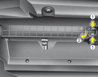 2. Remove the climate control air filter cover while pressing the lock on the